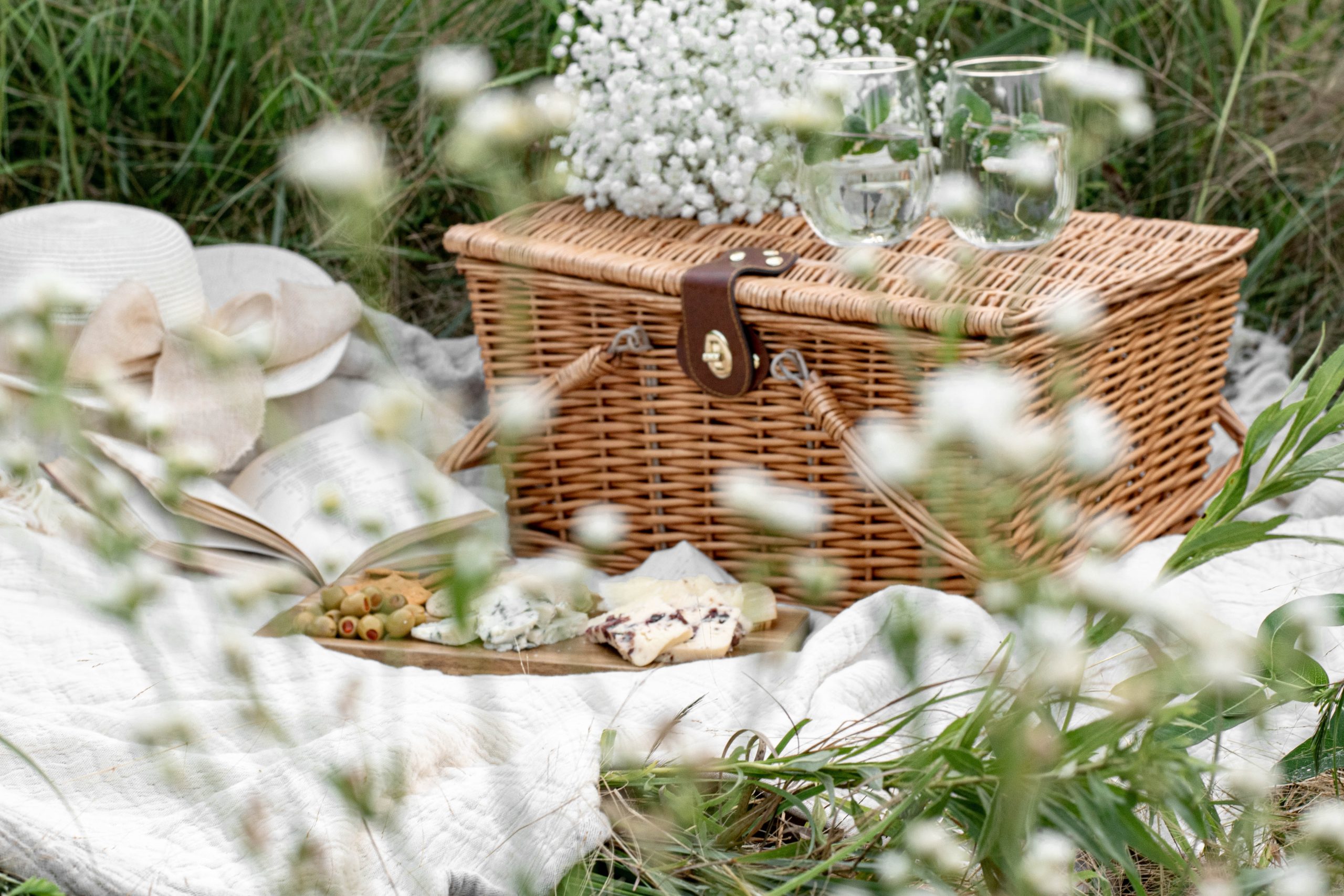 Aesthetic picnic outdoors with wine glasses bread berries and flowers.  Rustic picnic with neutral tones colours. Stock Photo by  ©lamapacas.gmail.com 378420028