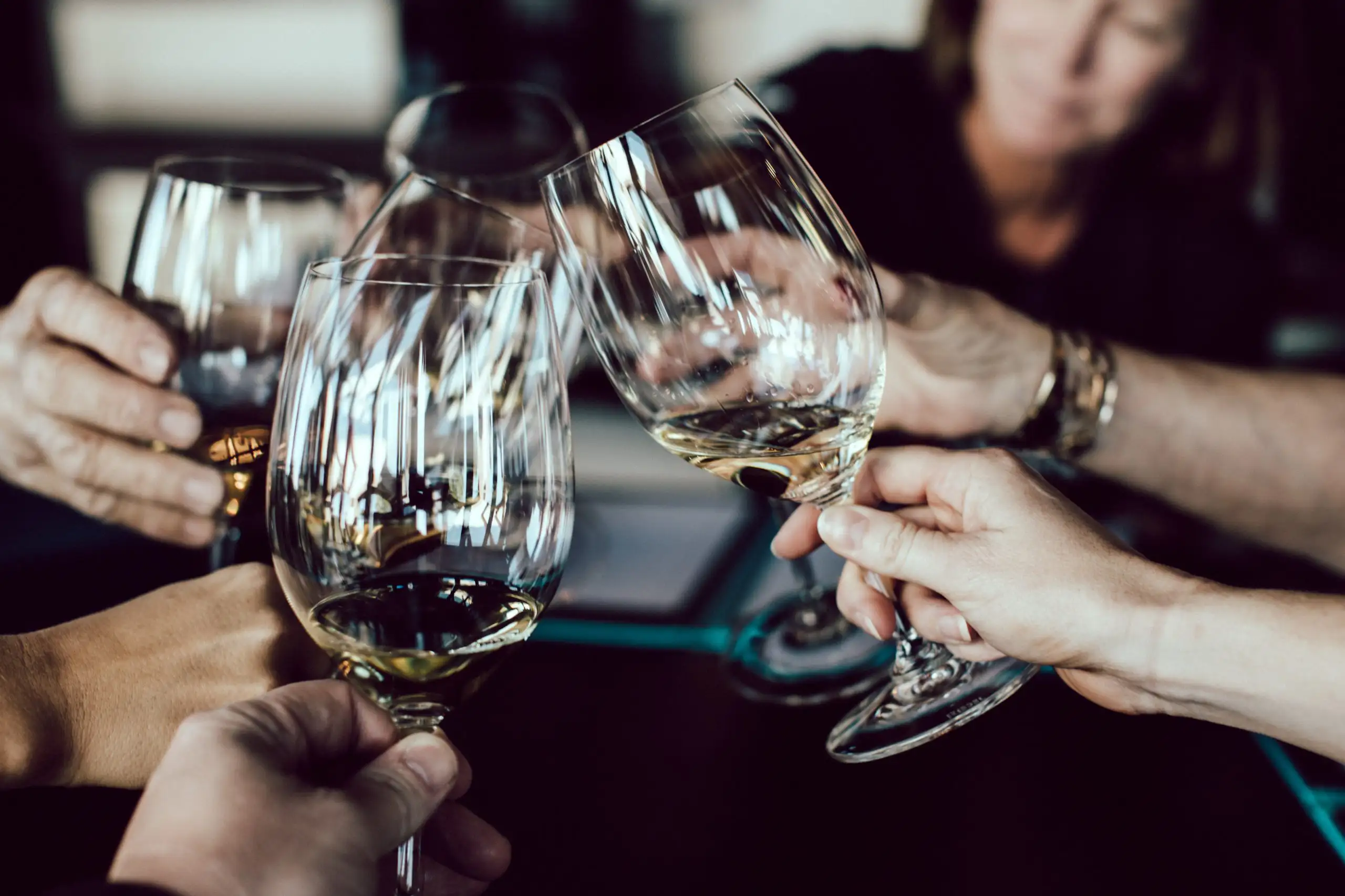 Why You Should Join a Wine Club, Now | Domenico Winery Friends clinking wine glasses together in a toast during a dinner gathering.