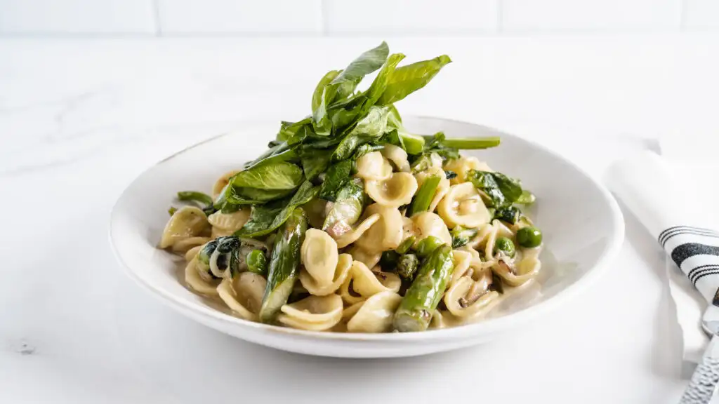 Italian Food 101: Pairing Wine with Pasta | Domenico Winery A bowl of pasta with asparagus, peas, and fresh basil on top.