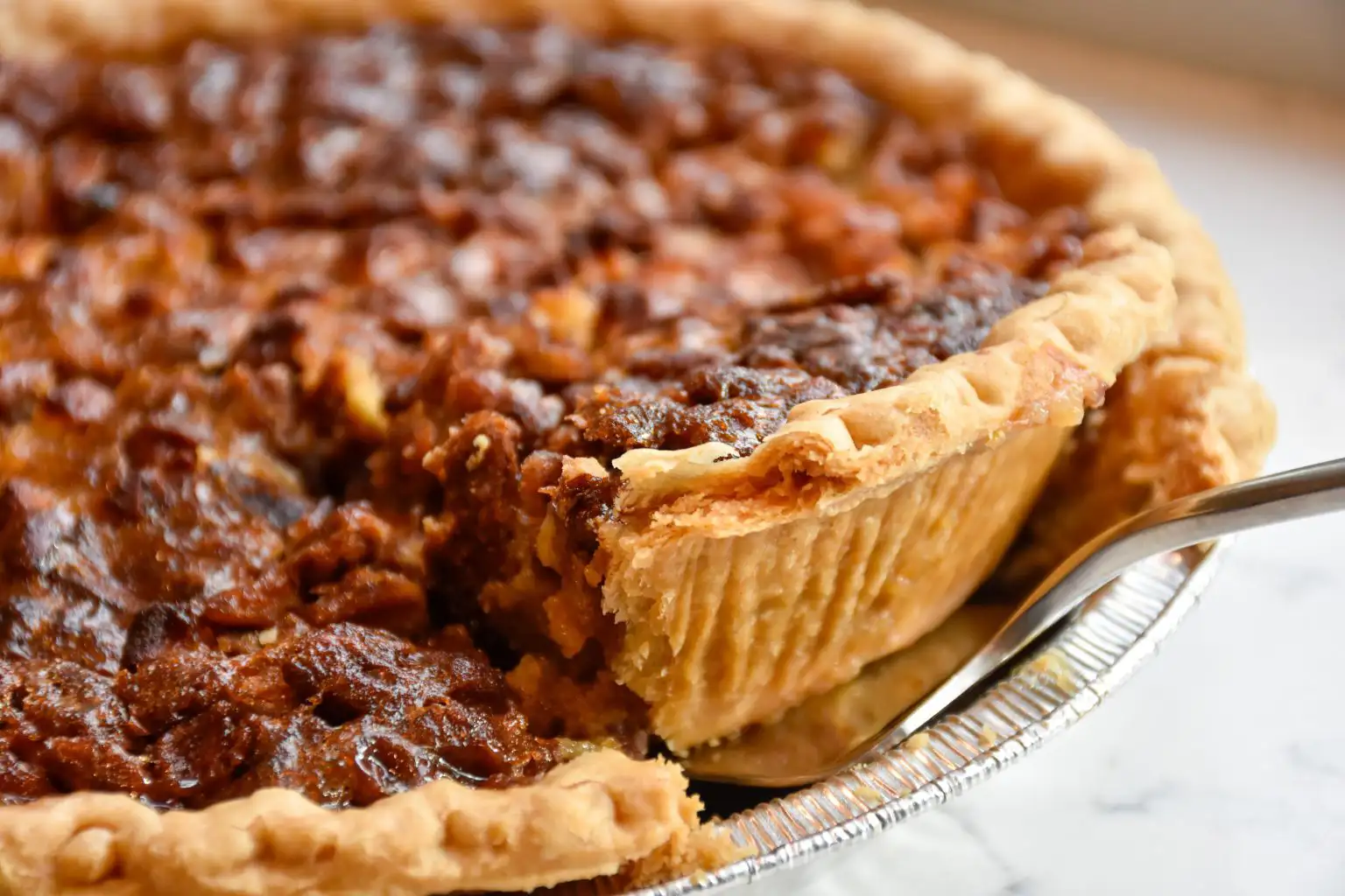 Wine and Pie Pairings that Will Change Your Life | Domenico Winery Close-up of a slice of pecan pie with a golden-brown crust and rich, gooey filling.